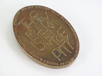 A bronze plaque or paperweight, dedicated to the war poet Wilfred Owen (1893-1918), cast with a poppy to one side, the reverse stating The Poetry is in the Pity, with various notes to the border. - 2