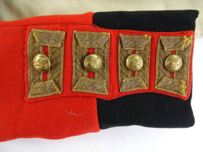 A George V period red military dress coat, with knot shoulder boards, black upright collar and black cuffs, gilt metal regimental buttons to front, collar and wrists, central slash to skirt, (AF). - 3