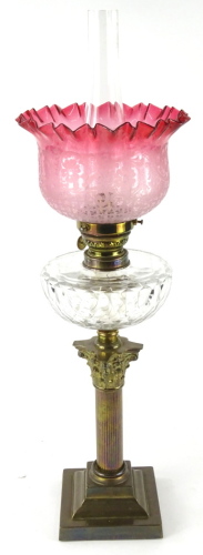 A late Victorian oil lamp, with W & B clear glass funnel, cranberry and etched glass shade, cut glass reservoir, and brass composite column stem, on a stepped base, 67cm high.