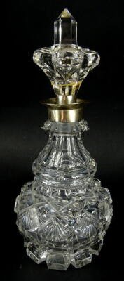 An early 20thC crystal perfume bottle, with crown stopper, white metal collar and neck and shouldered body, decorated with a repeat hobnail cut pattern on shaped feet, 23cm high.