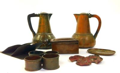 Two early 20thC Arts & Crafts beaten copper lidded jugs, with tapered bodies having swollen lappet bases, and with wooden handles, 17cm H and 18cm H, a small Arts & Crafts beaten rectangular box with lid, four napkin rings, a copper letter rack and two sm