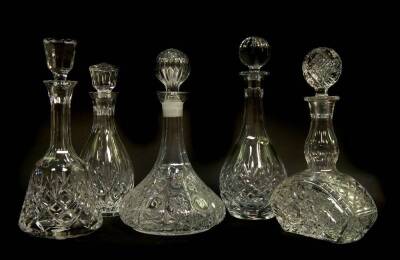 Five English and Continental cut and pressed glass decanters and stoppers, including a mallet shaped decanter and a ship's decanter.