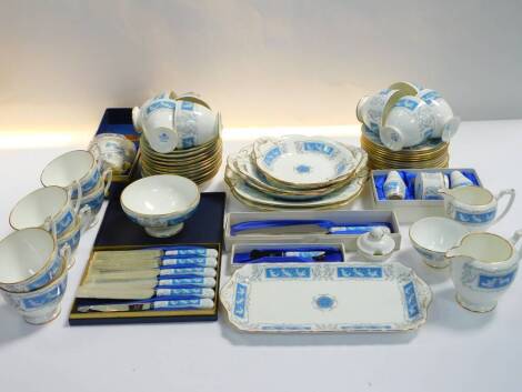 A Coalport porcelain tea service decorated in the Revelry pattern, comprising two graduated cream jugs, two sugar bowls, preserve pot cover, pair of bread plates, four graduated twin handled dishes, rectangular sandwich plate, three piece condiment set, c