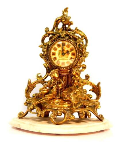 A French brass mantel clock by Rocha and Meirelles, Paris, the circular enamel dial bearing coat of arms and Roman numerals, quartz movement, the case of scrolling rococo form, cast with garlands of flowers and to the fore with seated figures, raised on a