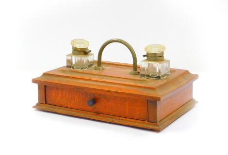 A Victorian oak and boxwood line inlaid desk stand, of rectangular section, with carrying handle and two cut glass ink wells, single frieze drawer, raised on a plinth base, 28cm W, 19cm D.