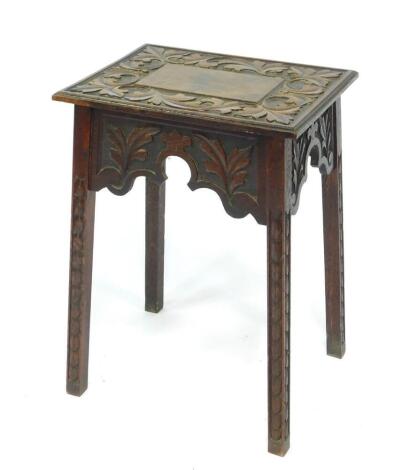 A Victorian oak side table, the rectangular top with carved scrolling leaf decoration, above similarly carved side friezes, raised on square outswept legs with repeating leaf carved decoration, 45cm W, 35cm D, 63cm H.