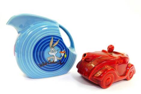 A Sadler pottery red motorcar teapot, no.820236, impressed marks, 22cm W, together with a Homer Laughlin china Fiesta pottery jug, decorated with Bugs Bunny "What's Cookin Doc?" and Foghorn Leghorn "Doo-Dah Doo-Dah", 18cm H. (2)