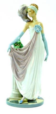 A Lladro porcelain figure of a lady, modelled standing in 1920's costume, against a fluted column with a jardiniere containing a plant, raised on an oval base, no.5283, printed and impressed marks, 35cm H.