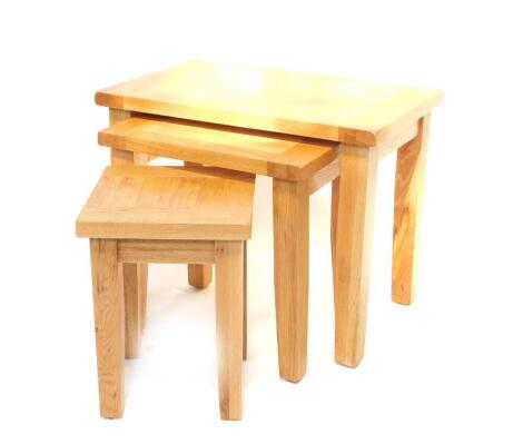 A light oak nest of occasional tables, with rectangular tops and slightly square tapered legs, the largest table measures 54cm H, 68cm W, 44cm D.