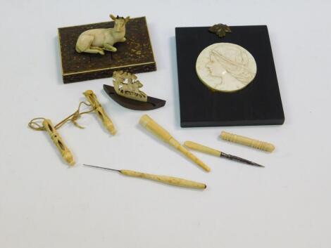 A 19thC carved ivory figure, of recumbent deer, on a rectangular coloured ivory rustic plinth, 5cm H, a carved bone cameo style portrait miniature of a female head in profile, a small 19thC carved ivory miniature and Victorian ivory and bone handled needl