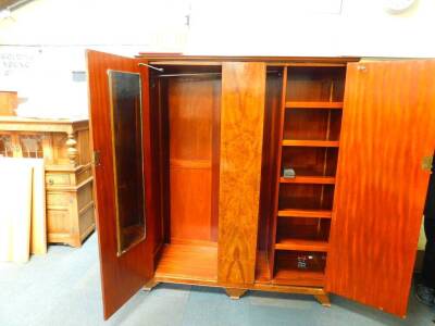 An early 20thC walnut and mahogany compactum wardrobe, the outswept pediment over two doors, flanking a centre panel opening to reveal a double hanging space, flanked by five shelves, raised on bracket feet, 191.5cm H, 157cm W, 56.5cm D. - 2