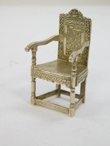 An early 20thC silver miniature model of a Wainscot chair, engraved decoration, import and further marks, possibly London 1904, 0.98oz.