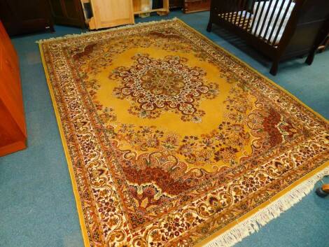 A Belgian wool Keshan super rug, decorated with a central floral medallion, in a surround of flowers and foliate motifs and border, against a camel brown ground, 348cm x 249cm.