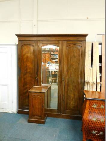 A Victorian oak compactum wardrobe, the outset pediment over a central door, inset domed bevelled glass, opening to reveal four linen slides over two drawers, flanked by hanging spaces with shelves above, flanked by two panelled doors, raised on a plinth 