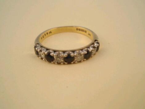 A half hoop eternity ring set alternately with five sapphires and four diamonds