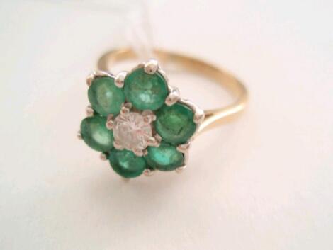 A ladies stone set flower cluster ring of a central small round diamond