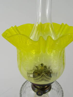 An early 20thC oil lamp, with clear funnel marked fire proof, with bear stamp, yellow clear and etched glass shade, brass shoulder, clear reservoir, and acanthus leaf stem, terminating in an octagonal base, 59cm high. - 2