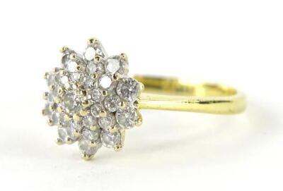 An 18ct gold diamond cluster ring, florally set with an arrangement of nineteen diamonds, central stone round brilliant 3.4mm x 1.8mm, approx 0.13cts with three tiers of graduating size small to large, ring head 1cm wide, on a plain shank marked 18ct, siz