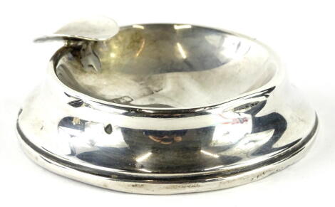 A 20thC silver ashtray, of circular form, with pipe rest, marks badly worn, 8cm wide, 6oz all in (AF, weighted).