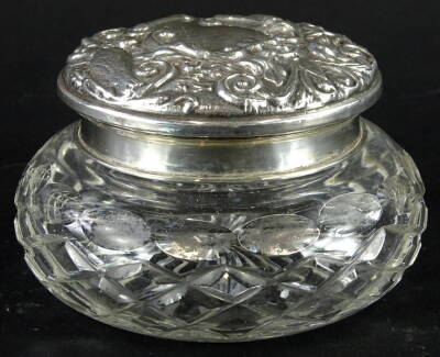 An Elizabeth II silver and cut glass powder box, the lid heavily repousse decorated with scrolls, the main section of compressed form hob nail cut with a repeat geometric pattern, the lid Birmingham 1958, 7cm high, 3½oz.