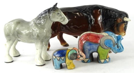 A Sylvac pottery figure of a bull, No. 3930, in brown and white colourway, impressed marks beneath, 18cm high, a multi colour elephant figure, another smaller and a Staffordshire Shire Range pottery horse in grey and white colourway (4).