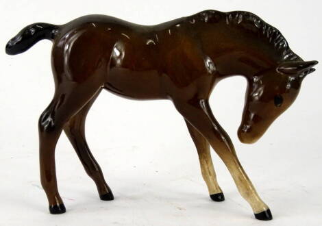 A Royal Doulton pottery foal, front foot raised, head lowered, brown and white colourway, printed marks beneath, 11cm high.