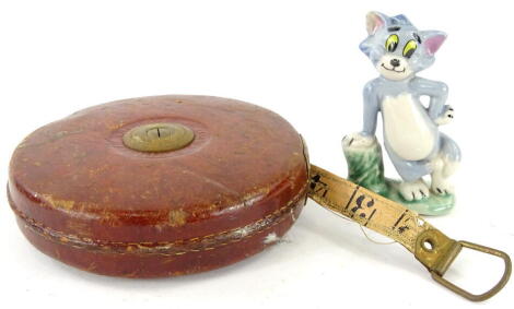 A Wade figure Tom, 10cm high, and an early 20thC circular leather tape measure marked John Rabone, No. 40166FT, 13cm diameter. (2 AF)