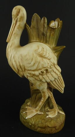 A Crown Devon Fieldings stork spill vase, in gilt and yellow, printed marks beneath, 26cm high, (AF).
