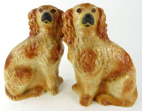 A pair of late 19thC Staffordshire pottery spaniels, each in brown and black colourway, with glass eyes and moulded chains and collars, unmarked, 34cm high (2).