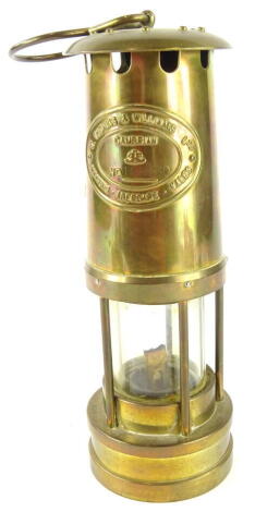 A 20thC Thomas and Williams Cambrian miner's lamp, No. 108760, of cylindrical form with glass centre, 'S' shaped hook top and front plaque, 28cm high.