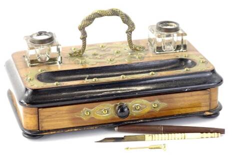 A Victorian walnut and brass ink stand, with two moulded glass inkwells and a frieze drawer enclosing pens, 26cm W.