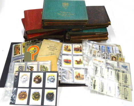 Various cigarette and trade cards in albums, to include Golden Era Classic Tractors, Famous TT Riders, Lifeboat Institution cards, Rockwell cards Early Locomotive, Player & Sons, Railway equipment, Wills, Churchmans, a large quantity of others in various 