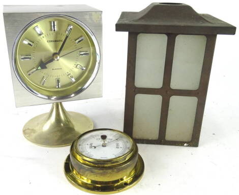 A Coramatic four jewel retro mantel clock, in square case, on inverted stem and circular foot, with shaped dial, 18cm high, a reproduction brass barometer and a pewter hanging lantern shade with frosted glass panels (3).