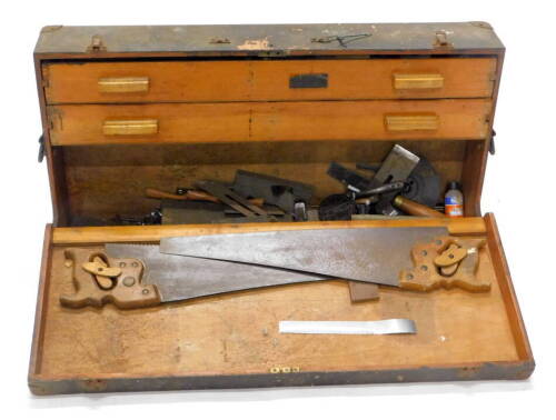 A 19thC tool cabinet, of rectangular form, with metal locks and side handles, 17cm high, 85cm wide, 46cm deep, set with two pine drawers containing a quantity of early 20thC tools, wood planes, hand drill, saws, other bits etc. (a quantity).