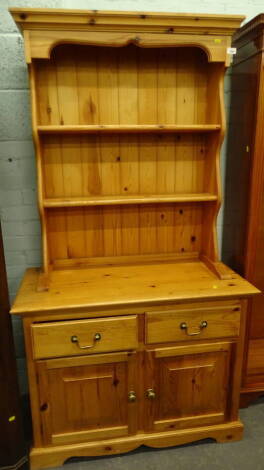 A pine kitchen dresser with moulded cornice, raised above open delft shelves and two frieze drawers with double cupboard beneath, 185cm high, 100cm wide, 48cm deep.