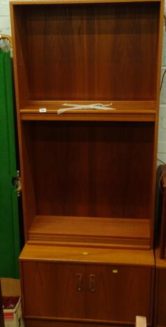 A 1970's G Plan bookcase with open shelves, above a double cupboard, label to the interior, 199cm high, 80cm wide, 43cm deep.