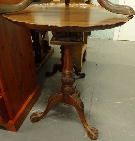 A mahogany occasional table in George III style, the circular top with a pie crust border on a turned reeded and carved column, tripod base with ball and claw feet, (AF), 60cm diameter.