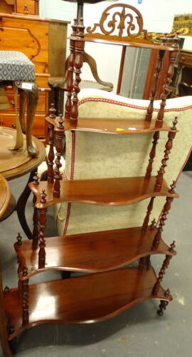 A Victorian mahogany what-not, with pierced crest above five graduated serpentine shaped shelves, each with turned and spirally turned supports, on turned feet, 73cm wide at its widest.