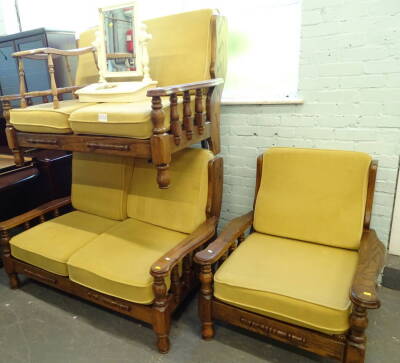 A pair of oak framed two seater sofas and an armchair. (3) The upholstery in this lot does not comply with the 1988 (Fire & Fire Furnishing) Regulations, unless sold to a known exporter or upholsterer it will be cut from the frame before leaving the premi