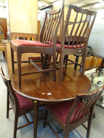 A Stag circular extending dining table and five chairs, the table with a circular top on shaped legs, 87cm high.