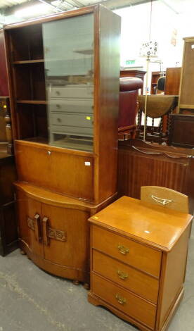 An oak bookcase, with glazed doors and serpentine front, on compressed bun feet, 170cm high, 76cm wide, 25cm deep, a pedestal cabinet of three drawers and a teak framed mirror (2).