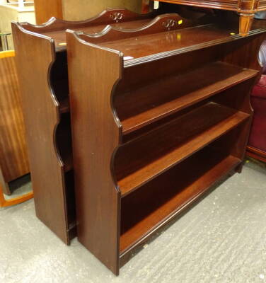 A pair of mahogany finish bookcases, each with fixed shelves and a moulded gallery top, 96cm high, 112cm wide, 31cm deep (2).