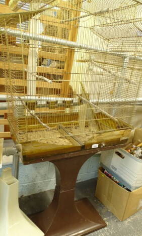 A meshwork bird cage with canopy top, on inverted brown plastic stand, 151cm high, 59cm wide, 35cm deep.