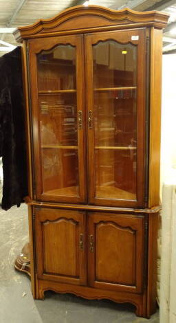 A freestanding corner cupboard, with double cupboard beneath, on shaped stiles, 191cm high, 83cm wide, 47cm deep.