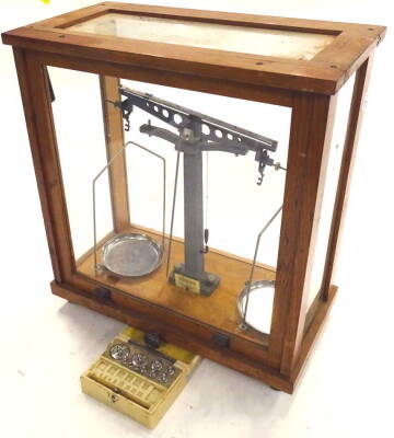 A set of 20thC oak cased scientific scales, with chrome plates in a glazed cabinet, 44cm high, 39cm wide, 23cm deep and a number of brass weights.