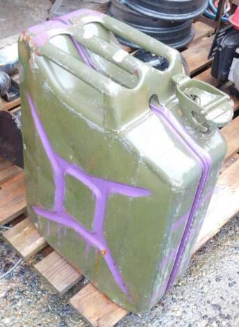 A military jerry can, dated 1987, green with purple over painting.