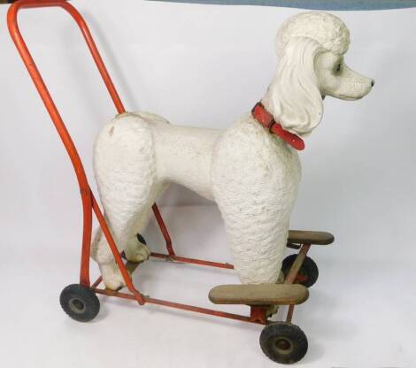 A vintage child's baby walker, in the form of a poodle with bent metal handle, articulated wheels and wooden front steps, 60cm high, unmarked. (AF)