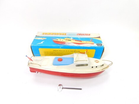 A Sutcliffe model Commodore clockwork all metal Cruiser, painted in red, white and blue, with key, boxed.