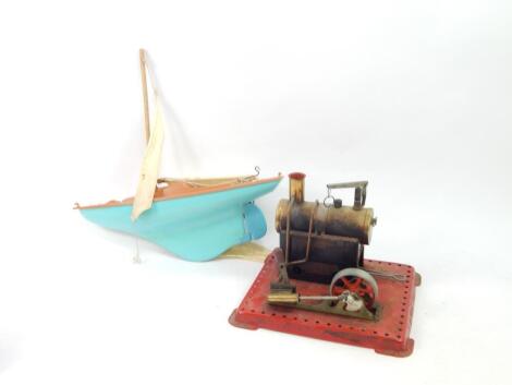 A Mamod stationary steam engine, with cylindrical boiler, on a red metal base, 16cm high and a Tri-ang Scalex racing yacht, boxed (2, A/F).