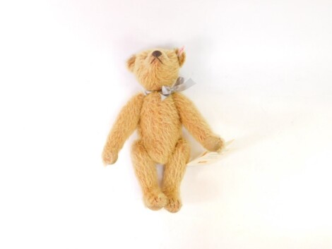 A Steiff plush jointed teddy bear, 2005, in light brown, with label to the ear and bow, 29cm high.